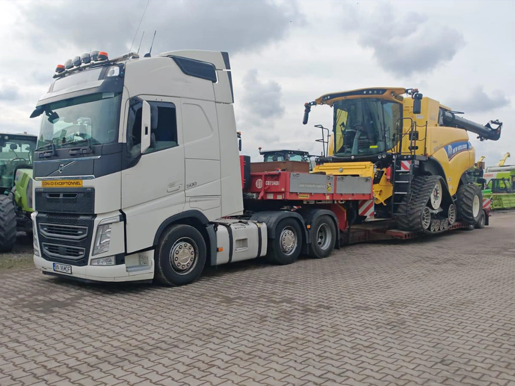 Camion Volvo si semitrailer transportand o combina agricola