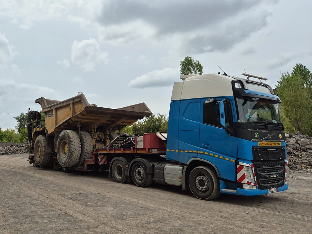 Camion Volvo si semitrailer transportand o autobasculanta pentru excavatii